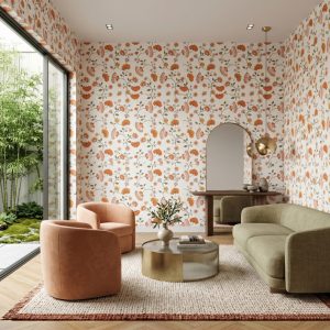 A modern living room featuring Clementine Vine Floral Wallpaper with retro orange and blush botanical flowers on a soft neutral background